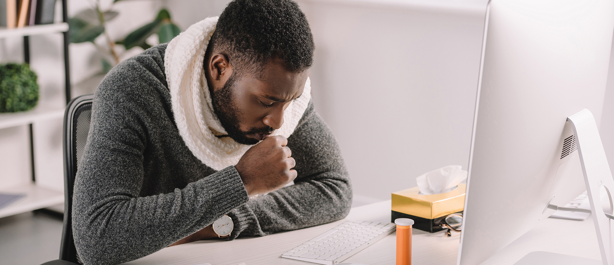 sick african american businessman coughing at workplace with medicines