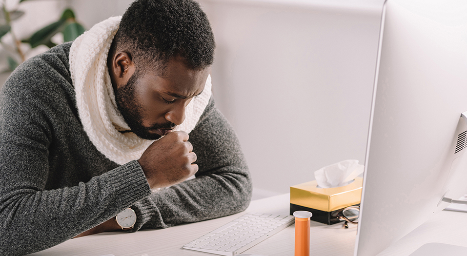 diseased african american businessman coughing at workplace with medicines