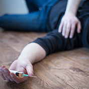 Man lying down on the floor after a drug overdose. He can be treated with Naxolone nasal spray